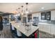 Open-concept kitchen with marble island, breakfast bar and stainless steel appliances next to a spacious living room at 7945 Placid Ct, Denver, NC 28037