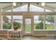 Cozy sunroom with view of the lake through many windows and a glass door leading to the back yard at 7945 Placid Ct, Denver, NC 28037