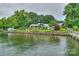 Waterfront view of home with manicured lawn and mature landscaping at 7945 Placid Ct, Denver, NC 28037