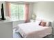 Bright bedroom with a large window, a bed with pink bedding, and a white dresser at 8060 Scarlet Maple Ln, Tega Cay, SC 29708