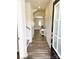 Bright foyer with hardwood flooring, white trim, arched doorway, and convenient coat closet, leading into living area at 8060 Scarlet Maple Ln, Tega Cay, SC 29708