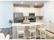 Well-lit kitchen featuring white cabinets, stainless steel appliances, quartz countertops and eat-in breakfast bar at 8060 Scarlet Maple Ln, Tega Cay, SC 29708