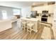 Open-concept kitchen and living area with modern appliances, light countertops, and a breakfast bar with seating at 8060 Scarlet Maple Ln, Tega Cay, SC 29708
