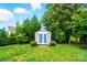 View of backyard shed with blue doors surrounded by green plants and grass at 8115 Kelburn Ln, Charlotte, NC 28273
