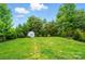 Well-maintained backyard featuring lush green grass, mature trees, and a charming storage shed at 8115 Kelburn Ln, Charlotte, NC 28273