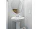 Well-lit powder room featuring a pedestal sink, round mirror, and neutral paint at 8115 Kelburn Ln, Charlotte, NC 28273