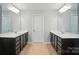 Symmetrical bathroom featuring dual sink vanities with dark cabinets and a neutral color scheme at 8115 Kelburn Ln, Charlotte, NC 28273