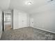 Spacious bedroom with plush carpeting, double-door closet, and access to other rooms at 8115 Kelburn Ln, Charlotte, NC 28273