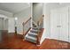 Elegant foyer showcasing hardwood floors, a carpeted staircase with iron spindles, and neutral paint at 8115 Kelburn Ln, Charlotte, NC 28273