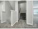Hallway featuring carpeted floors, white trim, and a staircase leading to the upper level at 8115 Kelburn Ln, Charlotte, NC 28273