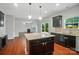 Open kitchen with granite island, dark cabinets, hardwood floors, and view to Gathering room at 8115 Kelburn Ln, Charlotte, NC 28273