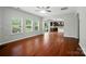 Bright and airy living room with hardwood floors, ceiling fan, and open view to the kitchen at 8115 Kelburn Ln, Charlotte, NC 28273