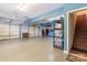 Large garage with three doors, stairs, and storage shelving at 8593 Bailey Dr, Terrell, NC 28682