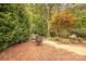 Brick patio featuring outdoor seating amidst mature landscaping and lush foliage at 901 Clearbrook Rd, Matthews, NC 28105