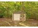 Backyard shed surrounded by lush greenery, offering storage or workspace at 901 Clearbrook Rd, Matthews, NC 28105