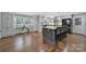 Sunlit kitchen features gray cabinets, an island with bar seating, and hardwood floors at 926 Meadow Lakes Rd, Rock Hill, SC 29732