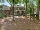 Spacious backyard with mature trees, a screened porch, and a wooden play structure at 9622 Penshurst Trce, Charlotte, NC 28210