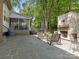 Relaxing backyard with patio, outdoor stone fireplace, rocking chairs, and screened-in porch with stairs at 9622 Penshurst Trce, Charlotte, NC 28210