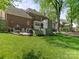 Well-manicured backyard with a stone fireplace, outdoor seating, and lush lawn at 9622 Penshurst Trce, Charlotte, NC 28210