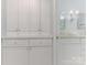 Bathroom featuring white vanity, mirrored cabinets, and adjacent doorway at 9622 Penshurst Trce, Charlotte, NC 28210