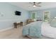 Light-filled bedroom with a TV, bench, and two windows overlooking a wooded area at 9622 Penshurst Trce, Charlotte, NC 28210