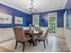 Dining room with blue walls and a round wood table beneath an elegant chandelier at 9622 Penshurst Trce, Charlotte, NC 28210