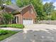 Brick exterior featuring attached garage, basketball hoop, driveway, and manicured landscaping at 9622 Penshurst Trce, Charlotte, NC 28210