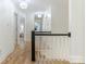 Light-filled hallway featuring hardwood floors, modern lighting and white trim at 9622 Penshurst Trce, Charlotte, NC 28210