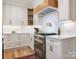 Well-lit kitchen featuring white cabinets, stainless steel appliances, and light wood flooring at 9622 Penshurst Trce, Charlotte, NC 28210