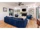 Inviting living room featuring a fireplace, shelving, hardwood floors, and a comfortable blue sofa at 9622 Penshurst Trce, Charlotte, NC 28210