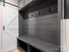 Mudroom area with gray bench, storage, coat hooks, and a white sliding barn door at 9622 Penshurst Trce, Charlotte, NC 28210