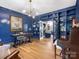 Elegant blue office with custom built-ins, hardwood floors, and a view into the formal living room at 9622 Penshurst Trce, Charlotte, NC 28210