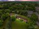 Expansive property featuring a brick home, additional brick building, and a barn surrounded by lush greenery at 10637 Highway 52 Hwy, Rockwell, NC 28138