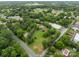 An aerial view of a wooded property with a brick home, a pond and long driveway in a residential area at 10637 Highway 52 Hwy, Rockwell, NC 28138