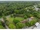 An aerial view of a wooded property with a brick home, a pond, an outbuilding and a long driveway at 10637 Highway 52 Hwy, Rockwell, NC 28138