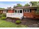A charming red brick home features a gray wooden deck, with white railings, that steps down to a garden at 10637 Highway 52 Hwy, Rockwell, NC 28138