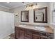 Bathroom with double sinks, wooden cabinets, framed mirrors, and modern lighting at 10637 Highway 52 Hwy, Rockwell, NC 28138