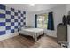 Cozy bedroom with a blue and white checkered accent wall, hardwood floors, and a comfortable bed at 10637 Highway 52 Hwy, Rockwell, NC 28138