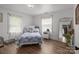 Serene bedroom with a quilted bedspread, hardwood floors, and soft natural light streaming through the windows at 10637 Highway 52 Hwy, Rockwell, NC 28138