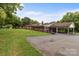 A sprawling red brick home with a covered carport and well maintained lawn, surrounded by mature trees at 10637 Highway 52 Hwy, Rockwell, NC 28138