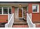 Inviting front porch with brick and stone accents, complemented by a wooden front door and white railings at 10637 Highway 52 Hwy, Rockwell, NC 28138