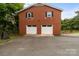 Two-story brick garage with two white doors, black shutters, a basketball net, and a paved driveway at 10637 Highway 52 Hwy, Rockwell, NC 28138
