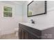 Stylish bathroom featuring a dark vanity, quartz countertop, and classic mirror at 1106 S South St, Gastonia, NC 28052