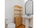 Bathroom with toilet, sink with vanity, modern mirror and cabinet with wooden slats at 1106 S South St, Gastonia, NC 28052