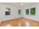 Sunlit bedroom with hardwood floors and windows offering views of the lush surrounding landscape at 1106 S South St, Gastonia, NC 28052