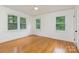 Bright bedroom with three windows offering a view of the greenery and hardwood floors at 1106 S South St, Gastonia, NC 28052