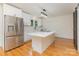 Bright kitchen features white cabinetry, stainless appliances, an island with cooktop, and sleek lighting at 1106 S South St, Gastonia, NC 28052