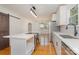 Kitchen with island cooktop, stainless appliances, white cabinets, and view to exterior front door at 1106 S South St, Gastonia, NC 28052