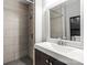Modern bathroom featuring a walk-in shower with tiled walls and a sleek vanity with a decorative mirror at 113 W 5Th Ave, Gastonia, NC 28052