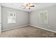 Bright bedroom featuring carpet floors, a ceiling fan, and natural light from two windows at 113 W 5Th Ave, Gastonia, NC 28052